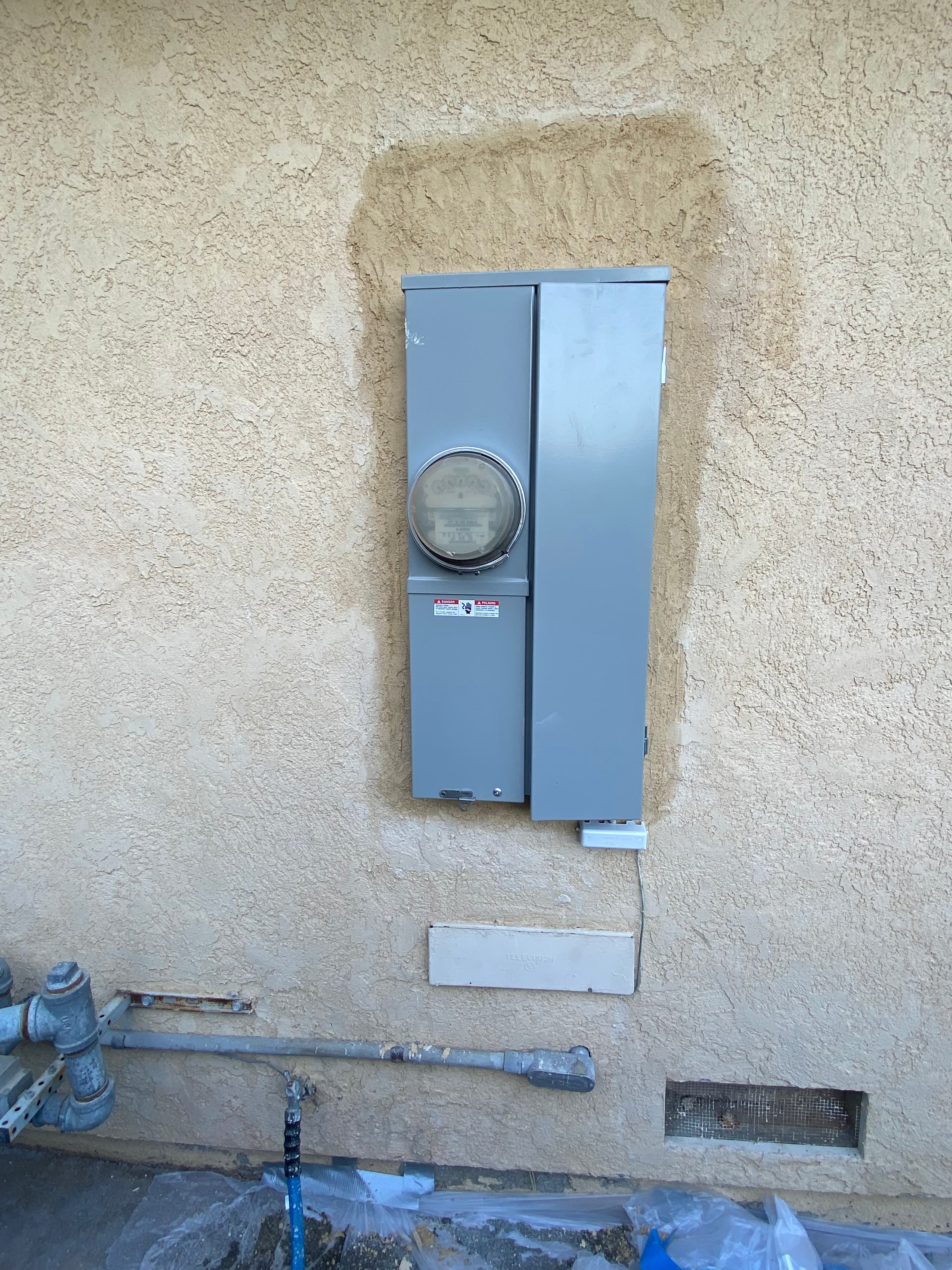 Exterior meter and main disconnect on a stucco wall