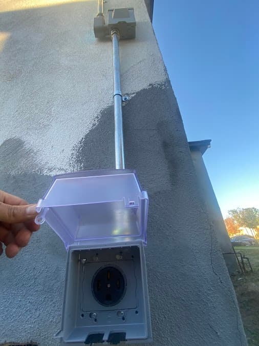 NEMA 14-50 EV charging outlet on exterior stucco wall